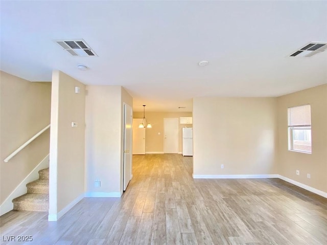5266 Souvenir Ln, Las Vegas, NV 89118 - spare room featuring light wood finished floors, stairway, a smoke detector, and a chandelier