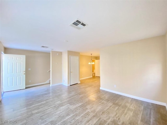 5266 Souvenir Ln, Las Vegas, NV 89118 - spare room featuring light wood-type flooring, stairs, and a chandelier