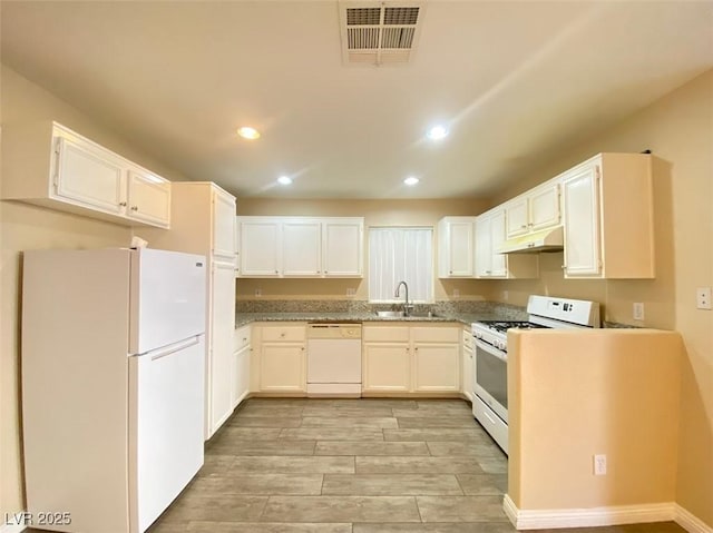 5266 Souvenir Ln, Las Vegas, NV 89118 - kitchen with white appliances, under cabinet range hood, recessed lighting, white cabinets, and light wood-style flooring