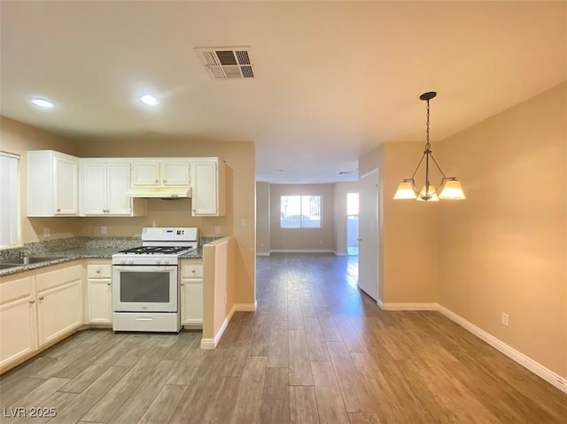 5266 Souvenir Ln, Las Vegas, NV 89118 - kitchen featuring white gas range, under cabinet range hood, light wood-style flooring, recessed lighting, and white cabinetry