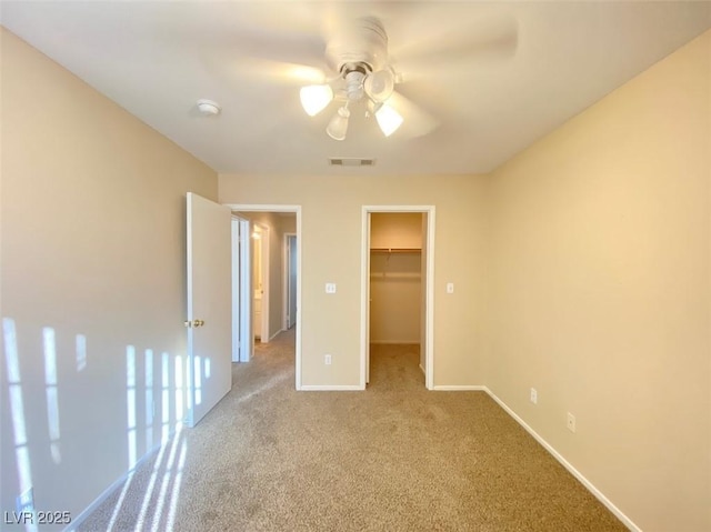 5266 Souvenir Ln, Las Vegas, NV 89118 - unfurnished bedroom featuring light colored carpet, a walk in closet, a ceiling fan, and a closet