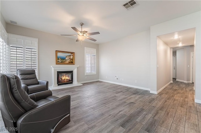 8424 Willowleaf Ct, Las Vegas, NV 89128 - unfurnished living room with a ceiling fan, wood finished floors, and a glass covered fireplace