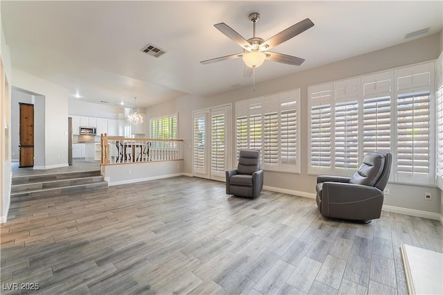 8424 Willowleaf Ct, Las Vegas, NV 89128 - living area featuring a ceiling fan, light wood-style flooring, and a chandelier
