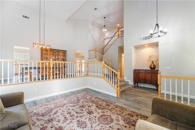 8424 Willowleaf Ct, Las Vegas, NV 89128 - living area with stairway, a chandelier, wood finished floors, and a towering ceiling