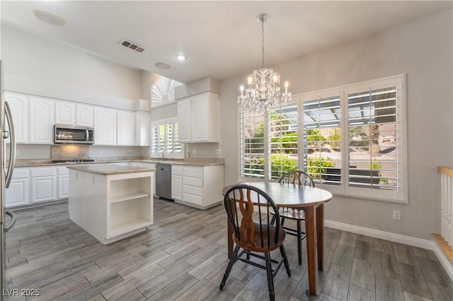 8424 Willowleaf Ct, Las Vegas, NV 89128 - kitchen with appliances with stainless steel finishes, a chandelier, wood finished floors, open shelves, and recessed lighting