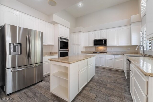 8424 Willowleaf Ct, Las Vegas, NV 89128 - kitchen with appliances with stainless steel finishes, open shelves, light stone countertops, white cabinetry, and a kitchen island