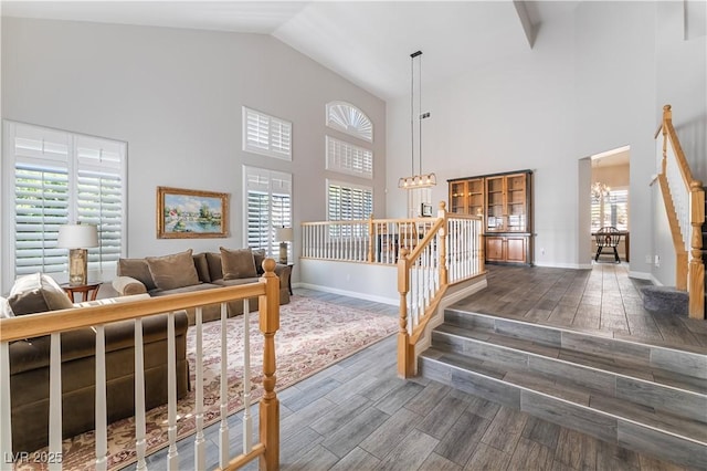 8424 Willowleaf Ct, Las Vegas, NV 89128 - stairway with high vaulted ceiling, wood finished floors, healthy amount of natural light, and a chandelier