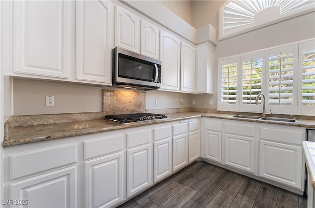 8424 Willowleaf Ct, Las Vegas, NV 89128 - kitchen with appliances with stainless steel finishes, white cabinetry, tasteful backsplash, and dark wood finished floors