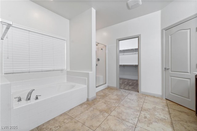 9217 Apollo Heights Ave, Las Vegas, NV 89149 - bathroom featuring a garden tub, a shower stall, a spacious closet, and tile patterned flooring