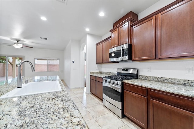 9217 Apollo Heights Ave, Las Vegas, NV 89149 - kitchen with appliances with stainless steel finishes, arched walkways, ceiling fan, light tile patterned flooring, and recessed lighting