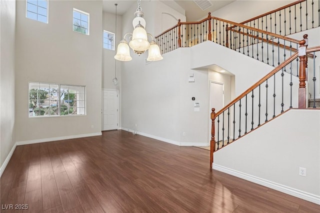 5541 Meridian Rain St, North Las Vegas, NV 89031 - unfurnished living room with a towering ceiling, wood finished floors, plenty of natural light, stairway, and a chandelier