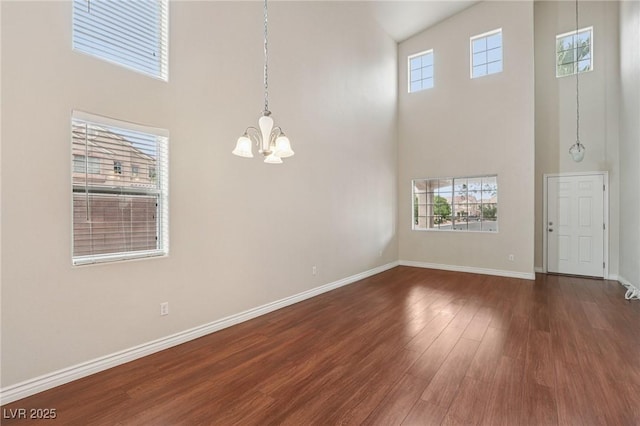 5541 Meridian Rain St, North Las Vegas, NV 89031 - empty room featuring a towering ceiling, a chandelier, and wood finished floors