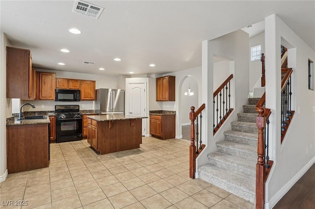 5541 Meridian Rain St, North Las Vegas, NV 89031 - kitchen featuring black appliances, a kitchen island, stone countertops, recessed lighting, and brown cabinets