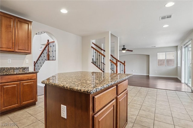 5541 Meridian Rain St, North Las Vegas, NV 89031 - kitchen featuring light tile patterned flooring, arched walkways, dark stone counters, and recessed lighting
