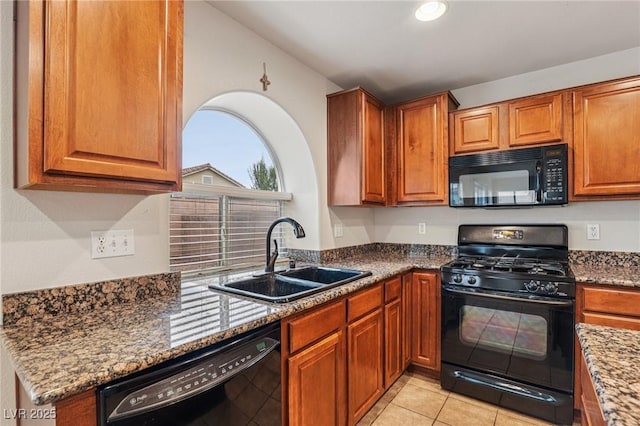 5541 Meridian Rain St, North Las Vegas, NV 89031 - kitchen featuring black appliances, brown cabinetry, stone counters, light tile patterned floors, and recessed lighting