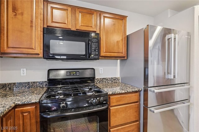 5541 Meridian Rain St, North Las Vegas, NV 89031 - kitchen with black appliances, brown cabinetry, and dark stone counters