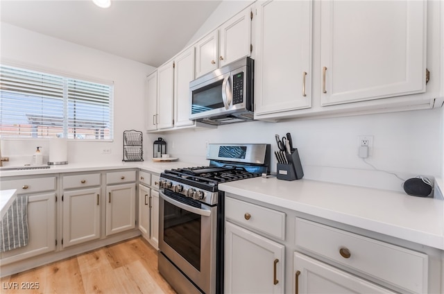 7909 Lovely Pine Pl, Las Vegas, NV 89143 - kitchen featuring stainless steel appliances, light countertops, light wood-style floors, and white cabinetry