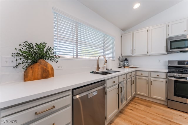 7909 Lovely Pine Pl, Las Vegas, NV 89143 - kitchen with stainless steel appliances, lofted ceiling, light countertops, light wood-style flooring, and white cabinets