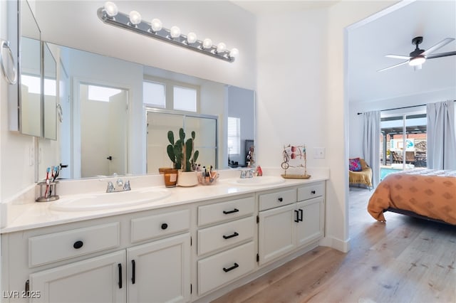 7909 Lovely Pine Pl, Las Vegas, NV 89143 - bathroom featuring double vanity, ensuite bathroom, wood finished floors, a shower with door, and ceiling fan