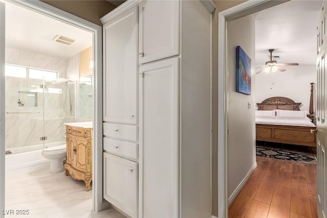 3938 Redfield Ave, North Las Vegas, NV 89032 - full bathroom with ceiling fan, ensuite bath, shower / bath combination with glass door, vanity, and wood-type flooring