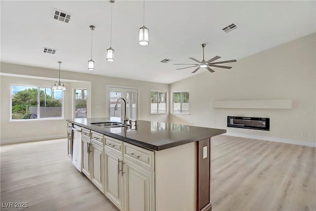 6125 Resort Ridge St, Las Vegas, NV 89130 - kitchen featuring dark countertops, light wood-style flooring, open floor plan, a ceiling fan, and an island with sink