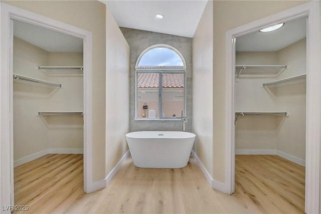 6125 Resort Ridge St, Las Vegas, NV 89130 - bathroom featuring a spacious closet, a soaking tub, and wood finished floors