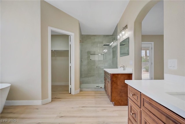 6125 Resort Ridge St, Las Vegas, NV 89130 - full bath with two vanities, a shower stall, wood finished floors, and a walk in closet