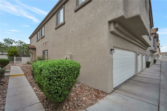 6388 Extreme Shear Ave Unit 103, Henderson, NV 89011 - view of home's exterior featuring stucco siding and an attached garage