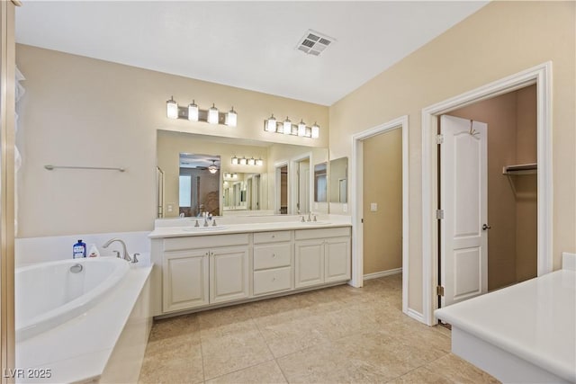 1084 Via Della Costrella, Henderson, NV 89011 - full bath with double vanity, a garden tub, tile patterned flooring, a ceiling fan, and a walk in closet