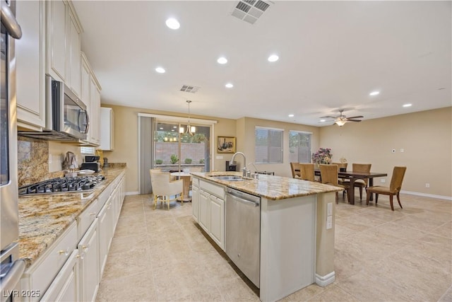 1084 Via Della Costrella, Henderson, NV 89011 - kitchen with appliances with stainless steel finishes, recessed lighting, light tile patterned floors, healthy amount of natural light, and a center island with sink