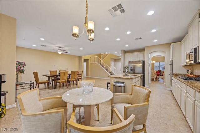1084 Via Della Costrella, Henderson, NV 89011 - dining area with a ceiling fan, arched walkways, recessed lighting, a chandelier, and stairs