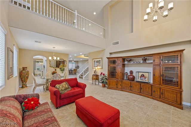 1084 Via Della Costrella, Henderson, NV 89011 - living room with a chandelier, light tile patterned floors, stairway, arched walkways, and a high ceiling