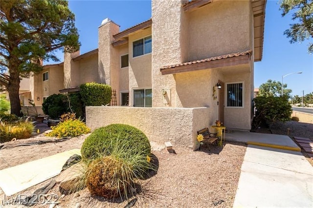 3393 Narod St, Las Vegas, NV 89121 - view of front facade with stucco siding, a chimney, and a tiled roof