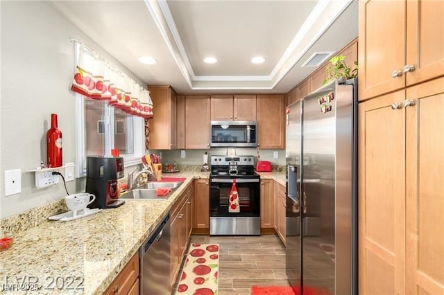 3393 Narod St, Las Vegas, NV 89121 - kitchen with appliances with stainless steel finishes, a raised ceiling, light wood-type flooring, light stone counters, and recessed lighting
