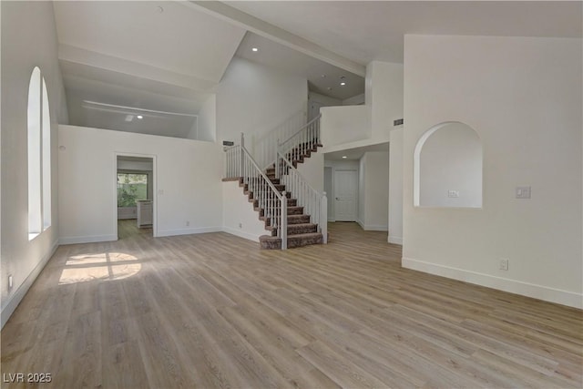 7629 Oyster Cove Dr, Las Vegas, NV 89128 - unfurnished living room featuring high vaulted ceiling, stairway, and light wood finished floors