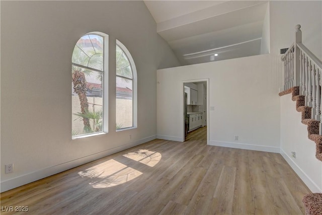 7629 Oyster Cove Dr, Las Vegas, NV 89128 - unfurnished room featuring light wood-type flooring, stairs, and high vaulted ceiling