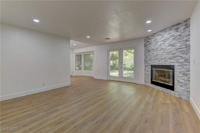 7629 Oyster Cove Dr, Las Vegas, NV 89128 - unfurnished living room featuring recessed lighting, a stone fireplace, and light wood finished floors