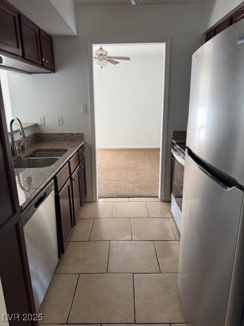 793 Oakmont Ave Unit 202, Las Vegas, NV 89109 - kitchen featuring stainless steel appliances, dark brown cabinets, a ceiling fan, light tile patterned flooring, and light colored carpet