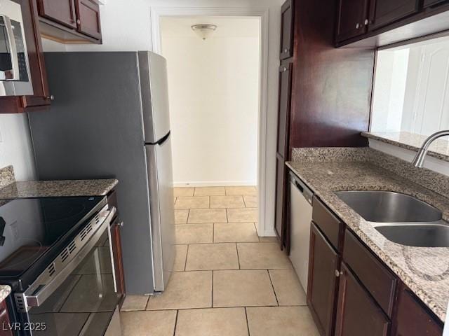 793 Oakmont Ave Unit 202, Las Vegas, NV 89109 - kitchen with stainless steel appliances, light stone countertops, light tile patterned floors, and dark brown cabinetry