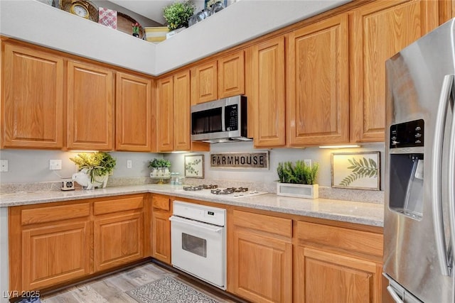 9553 Gainey Ranch Ave, Las Vegas, NV 89147 - kitchen featuring appliances with stainless steel finishes, light stone counters, and light wood-style floors