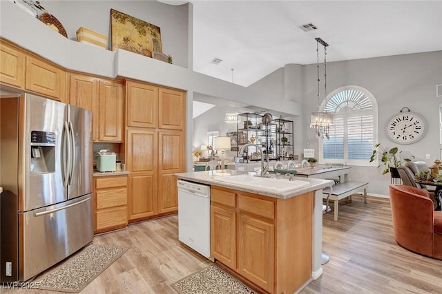 9553 Gainey Ranch Ave, Las Vegas, NV 89147 - kitchen with stainless steel refrigerator with ice dispenser, dishwasher, light wood-style floors, light brown cabinets, and light countertops
