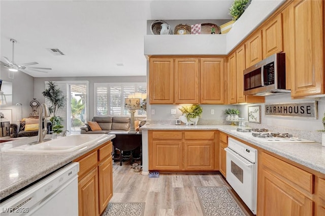 9553 Gainey Ranch Ave, Las Vegas, NV 89147 - kitchen with white appliances, open floor plan, light wood-style flooring, light countertops, and ceiling fan
