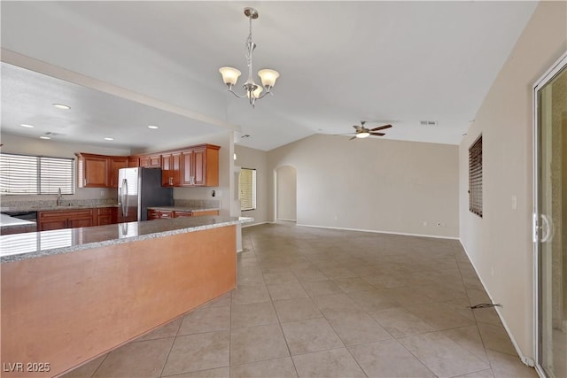 1770 W Charleston Park Ave, Pahrump, NV 89048 - kitchen featuring freestanding refrigerator, a ceiling fan, a chandelier, arched walkways, and lofted ceiling