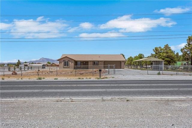 1770 W Charleston Park Ave, Pahrump, NV 89048 - view of front facade with a garage, driveway, a fenced front yard, a carport, and a mountain view