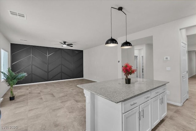 487 Via Renata, Henderson, NV 89044 - kitchen with a ceiling fan, white cabinets, a kitchen island, pendant lighting, and light stone counters