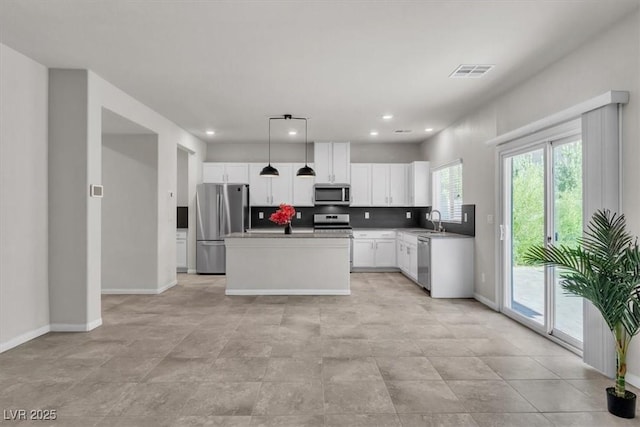 487 Via Renata, Henderson, NV 89044 - kitchen with stainless steel appliances, white cabinets, decorative light fixtures, a kitchen island, and recessed lighting