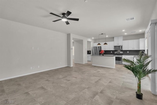 487 Via Renata, Henderson, NV 89044 - kitchen with appliances with stainless steel finishes, open floor plan, white cabinetry, pendant lighting, and ceiling fan