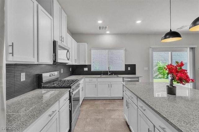 487 Via Renata, Henderson, NV 89044 - kitchen with stainless steel appliances, tasteful backsplash, white cabinetry, light stone countertops, and recessed lighting