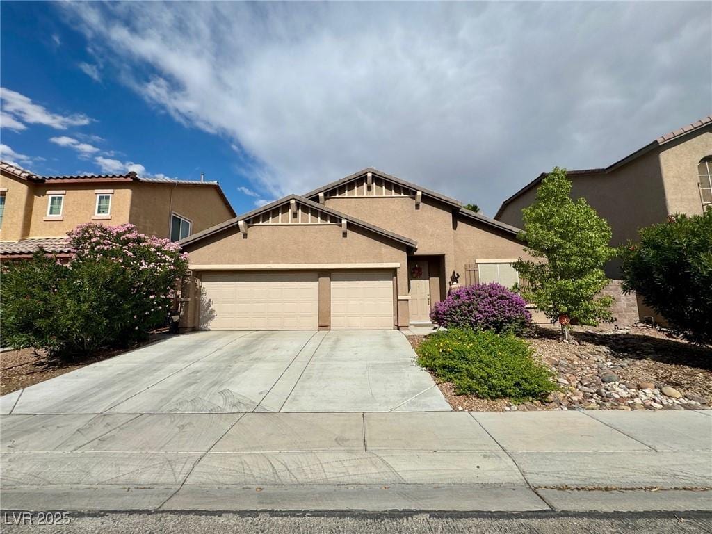 5528 Oatfield St, North Las Vegas, NV 89081 - view of front of house with an attached garage, concrete driveway, and stucco siding
