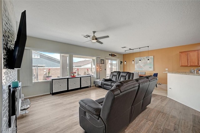 7460 Chaffinch St, North Las Vegas, NV 89084 - living area with light wood finished floors, a ceiling fan, and a textured ceiling
